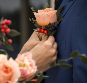 Rustic buttonhole with seasonal flowers and textured greenery for weddings