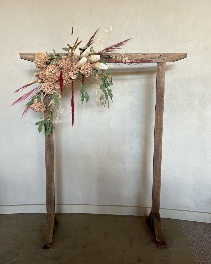 Wedding floral arch ceremony backdrop with preserved flowers and greenery designed by a professional florist