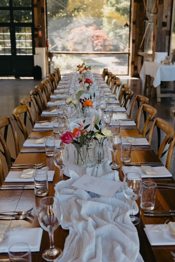 Wedding guest table decorated with elegant floral centerpieces designed by a professional florist