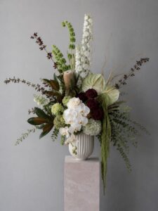 Designer fresh floral arrangement in a vase with contemporary flowers and foliage.