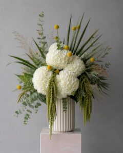 Fresh seasonal flowers arranged in a modern vase with sculptural styling.