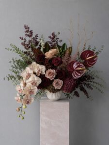 Sculptural fresh flower arrangement in a decorative vase with contemporary styling.