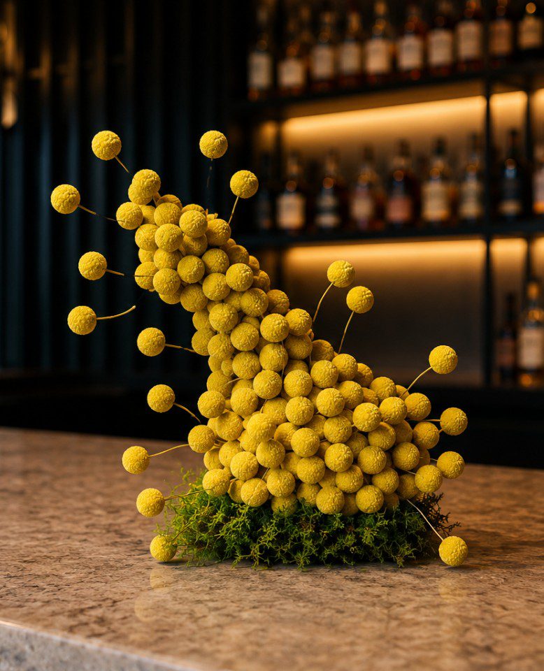 Corporate Florist Melbourne – Billy Buttons Floral Art on a Bar Reception Fay Flowers Modern floral art arrangement with vibrant yellow Billy Buttons displayed on a luxury bar reception, created by a Corporate Florist in Melbourne.