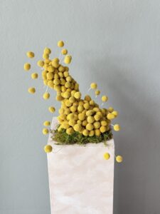 Modern floral art arrangement featuring vibrant yellow Billy Buttons, designed by a Corporate Florist in Melbourne for luxury office and commercial spaces.